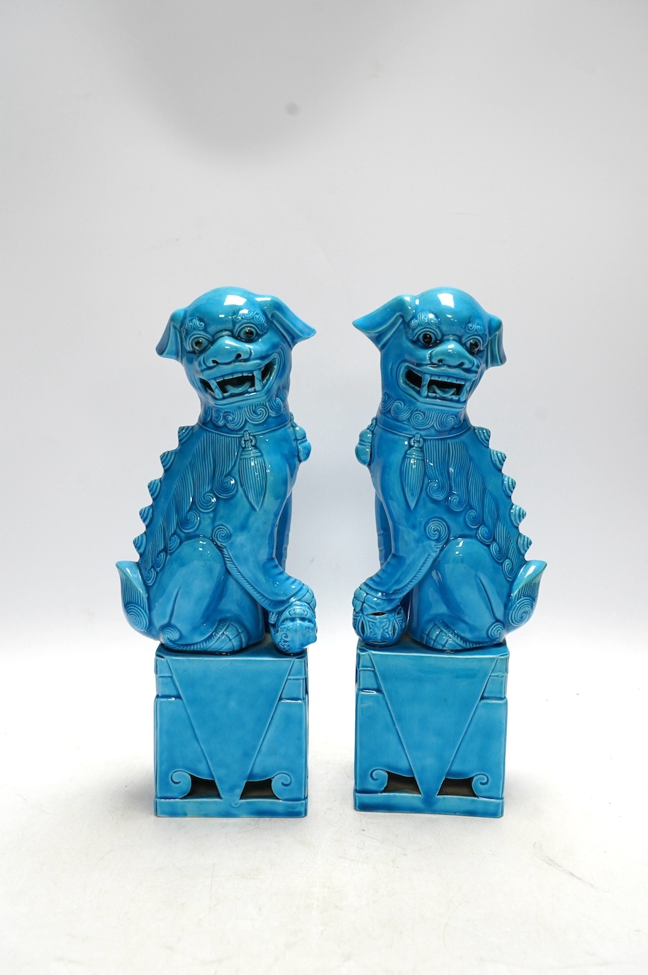 A pair of Chinese turquoise glazed lion dogs, 29cm. Condition - good